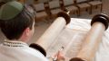 Young man reading from the Torah scroll