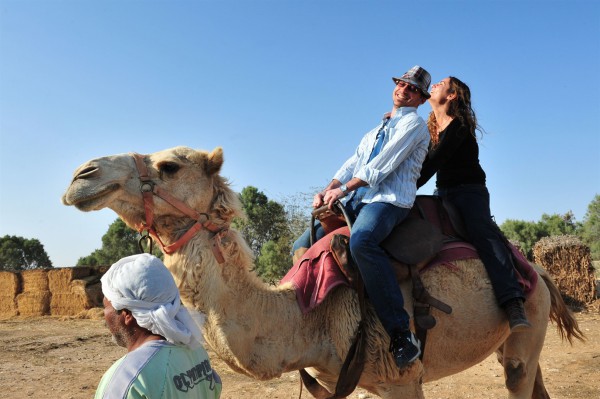 A husband and wife enjoy a camel ride together in Israel's Negev Desert.