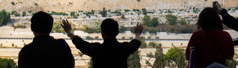 A Christian tourist on the Mount of Olives prays for the peace of Jerusalem.