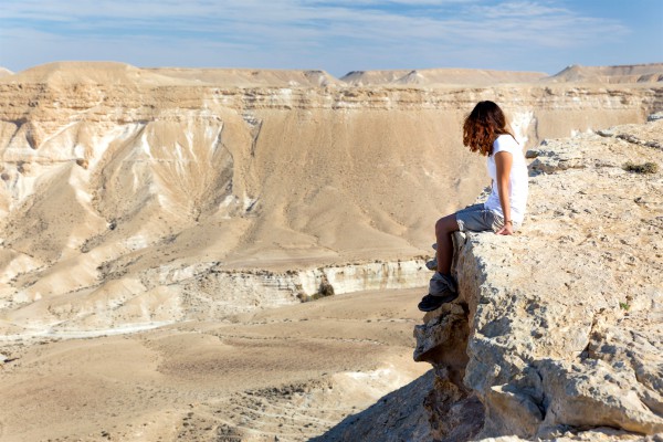 A woman sits alone in the Negev Desert.
