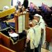 Reading from a Torah scroll encased in a protective Torah tik (case).