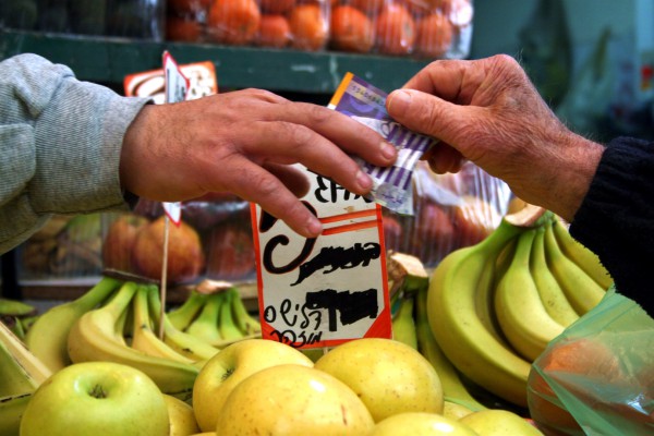 A senior purchases food in a market in Israel.