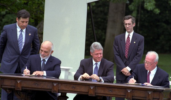 Prime Minister Yitzhak Rabin and Jordan's King Hussein sign the Washington Agreement on the White House lawn as US President Bill Clinton watches.