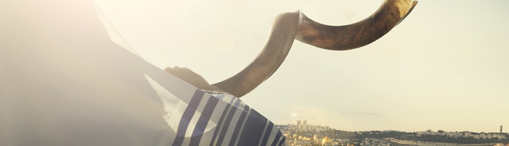 Jewish man blowing shofar over Jerusalem